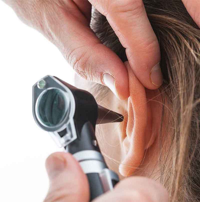 Hearing Specialist looking in a patients ear.